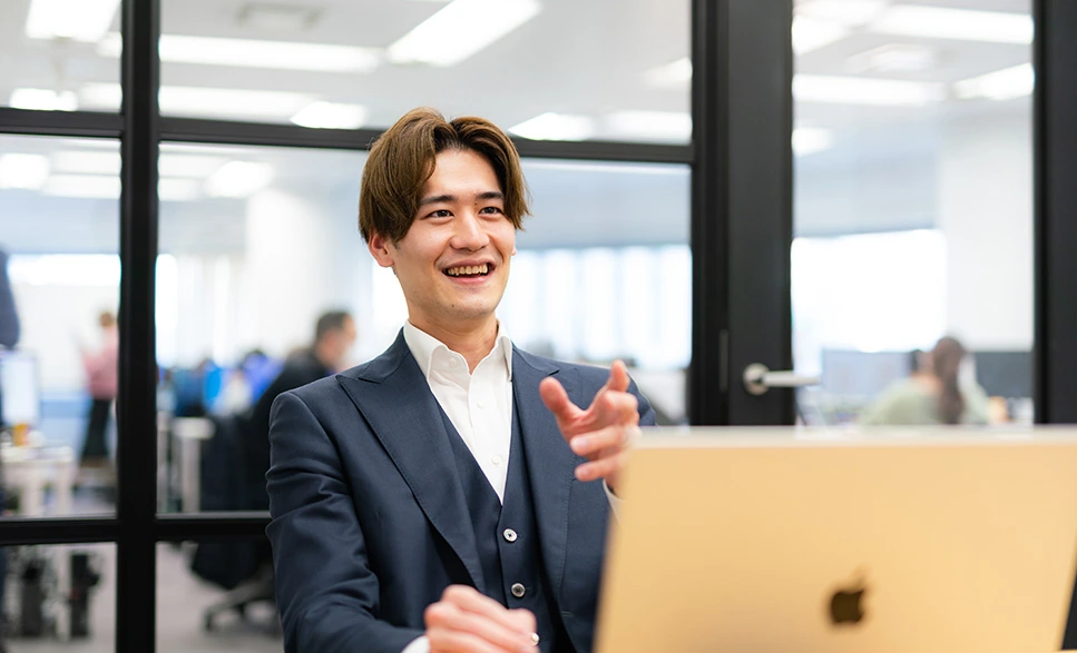 パソコンの前で話す男性スタッフ